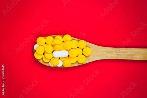 pharmaceutical medicine pills, tablets and capsules on wooden spoon