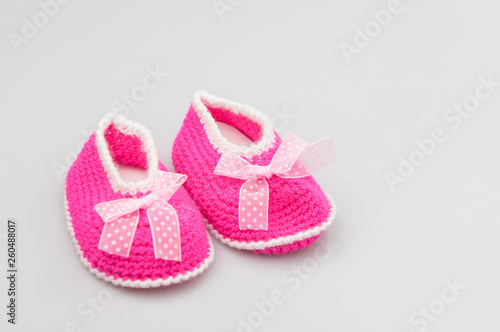 Baby girl shoes on white background, banner, copy space. Knitted baby booties.