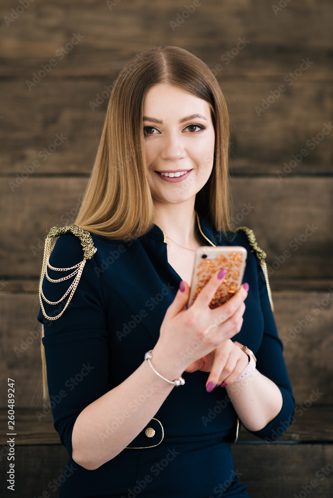 Portrait of a beautiful young stylish businesswoman in an interior Studio. Girl with phone in hand Portrait of a beautiful young stylish businesswoman in an interior Studio. Girl with phone in hand