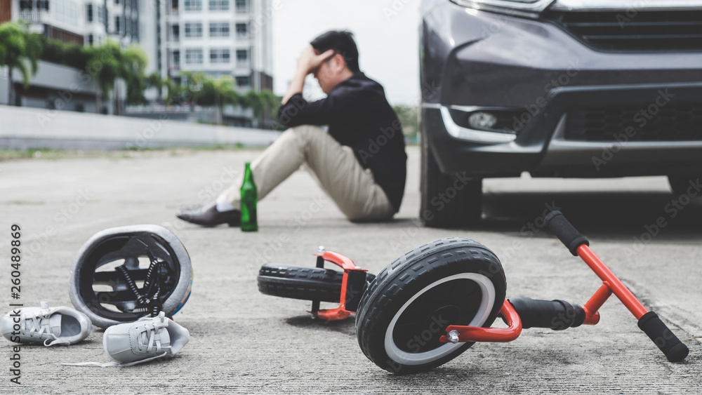 Image of shocked and scared driver after accident involved Kid's bike and helmet lying on the road on pedestrian crossing after accident collision with drunk car driver Image of shocked and scared driver after accident involved Kid's bike and helmet lying on the road on pedestrian crossing after accident collision with drunk car driver