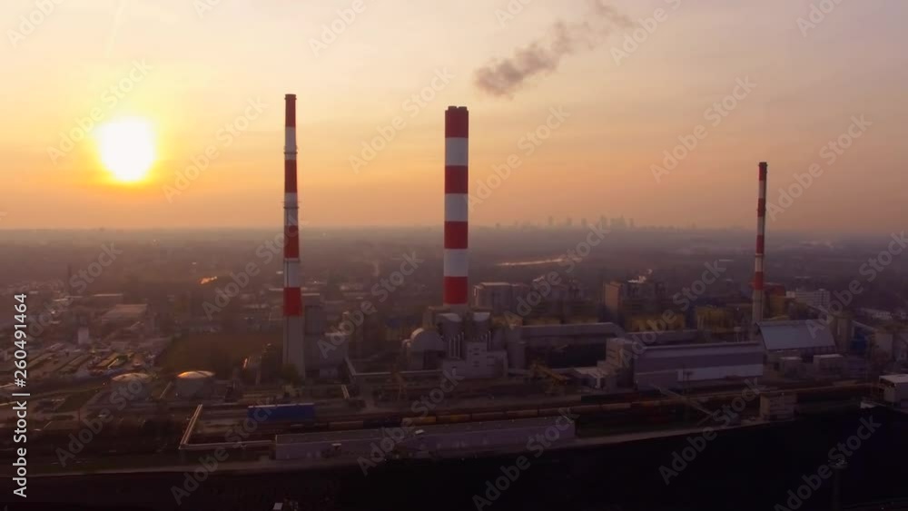 Aerial Flyover Of A Industrial Plant With Large Smoke Stacks Polluting At Sunrise Aerial Flyover Of A Industrial Plant With Large Smoke Stacks Polluting At Sunrise