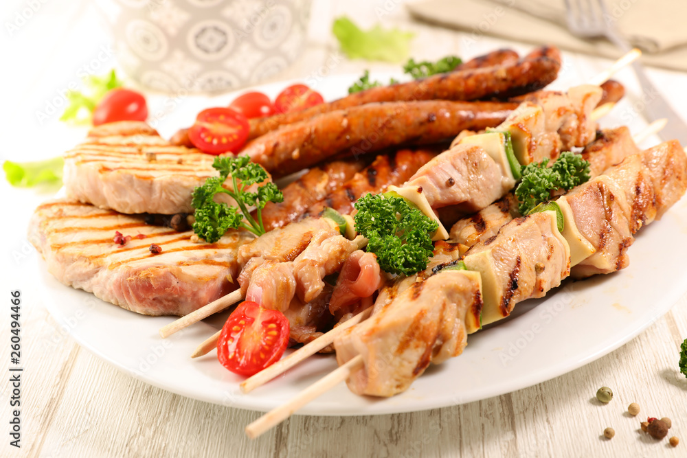 grilled sausage, pork chop and beef skewer with salad and sauce