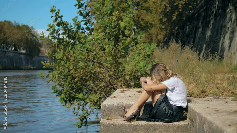 Desperation,loneliness,sadness. Lonely sad fashion woman crouched near the river