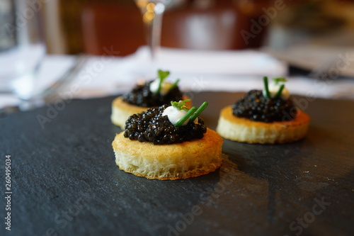 black caviar on a canape with sour cream