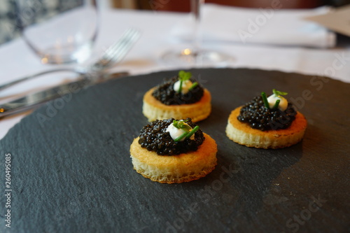 black caviar on a canape with sour cream