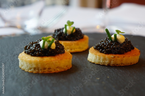 black caviar on a canape with soured cream