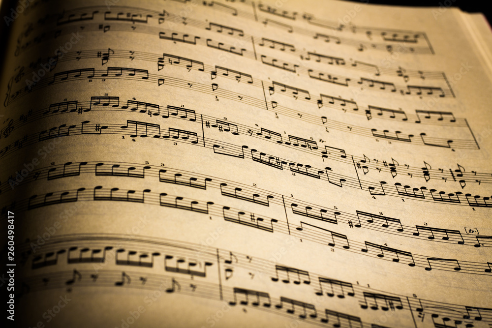 Close-up of sheet music page, in black background Close-up of sheet music page, in black background