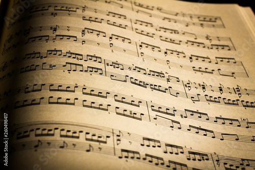 Close-up of sheet music page, in black background