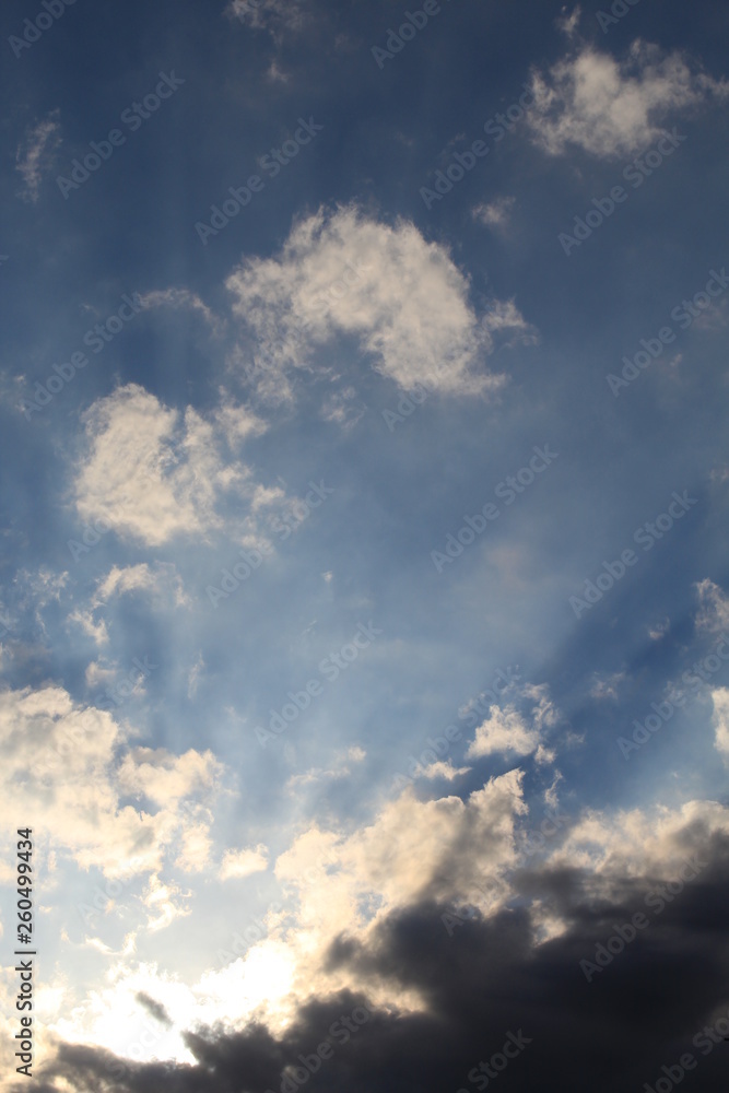 Fototapeta premium Raios solares entre nuvens no céu azul