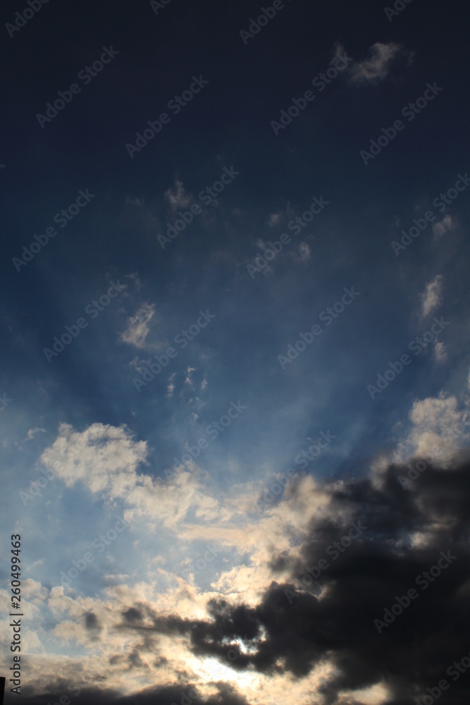 Raios solares entre nuvens no céu azul