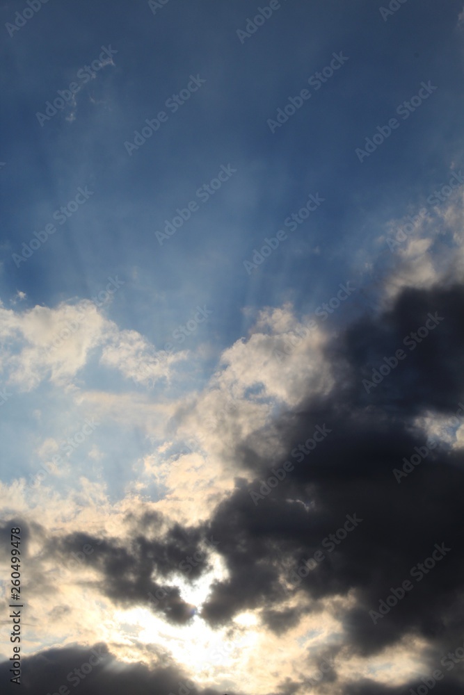 Raios solares entre nuvens no céu azul