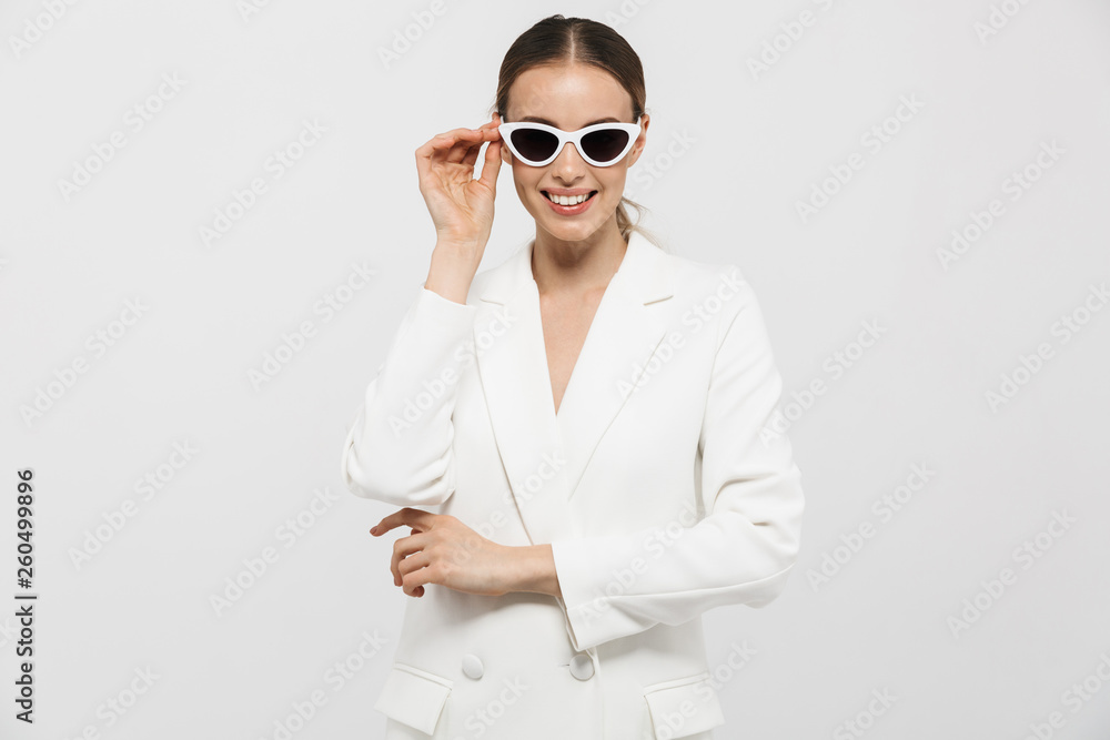 Beautiful happy woman posing isolated over white wall background wearing sunglasses. Beautiful happy woman posing isolated over white wall background wearing sunglasses.
