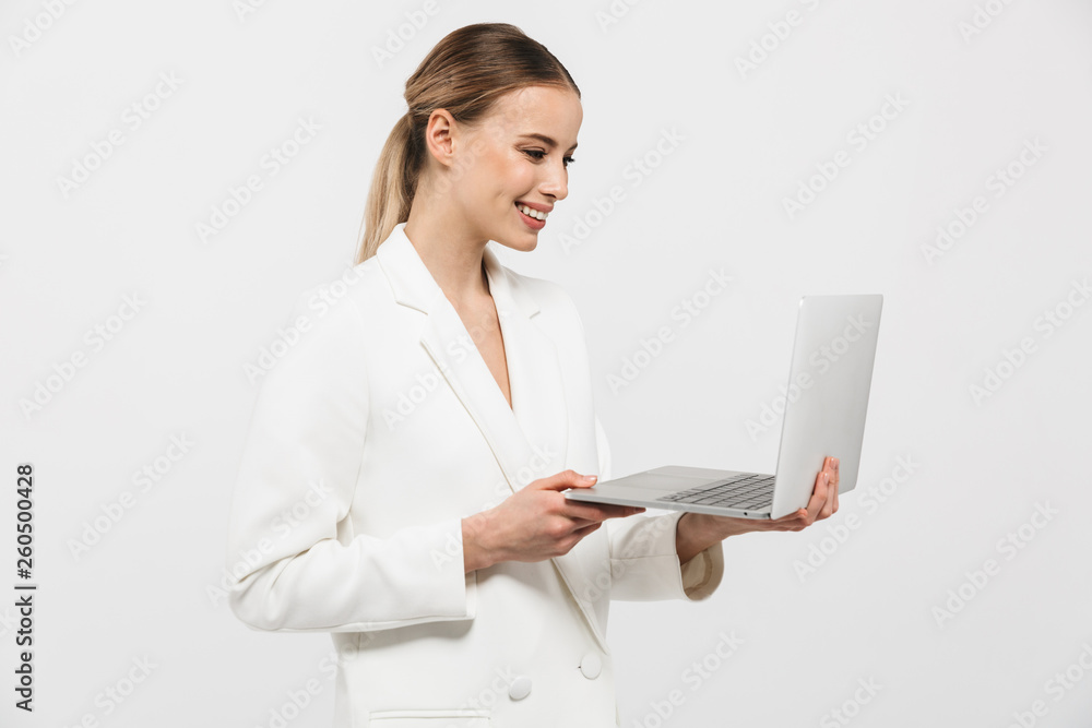 Beautiful happy amazing woman posing isolated over white wall background using laptop computer. Beautiful happy amazing woman posing isolated over white wall background using laptop computer.
