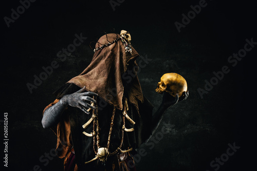Fototapeta Naklejka Na Ścianę i Meble -  Portrait of a shaman holding a human skull in his hands