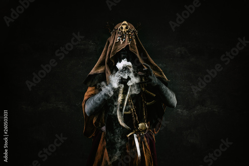Fototapeta Naklejka Na Ścianę i Meble -  Portrait of a shaman holding a steaming horn