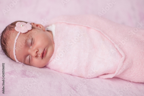 Little newborn baby in a pink suit on a pink background. Motherhood.
