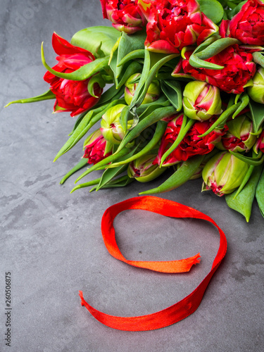 9 May background - red tulips and red ribbon on the concrete background, free space for text