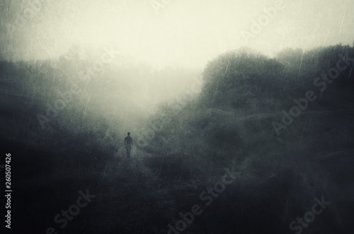 Fotografie solitude concept, man walking alone and contemplating in rain, dark  surreal lan