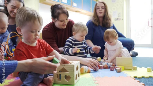 Group Of Mothers And Toddlers Playing With Toys At Playgroup
