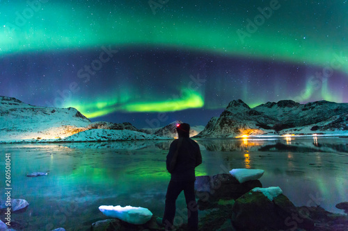 Northern lights at night with lonely man on front photo