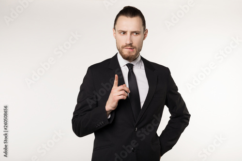 Happy beautiful bearded guy with good-looking hairstyle, wearing black suit and tie