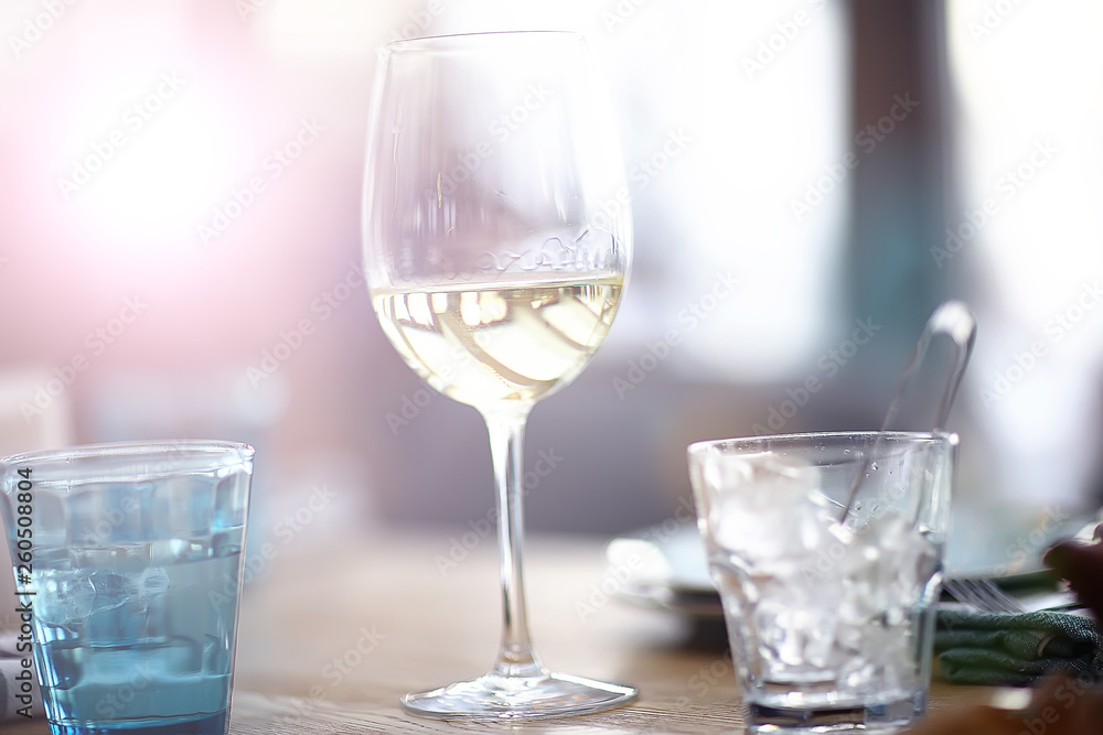 glass of white wine in the restaurant / white wine in the interior of the restaurant a table with glasses of wine, a romantic summer