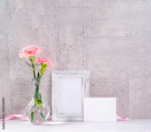Fototapeta Naklejka Na Ścianę i Meble -  Close up, copy space, mock up, beautiful mothers day event concept handmade giftbox decoration photography, blooming fresh carnations with pink color ribbon isolated on gray wallpaper