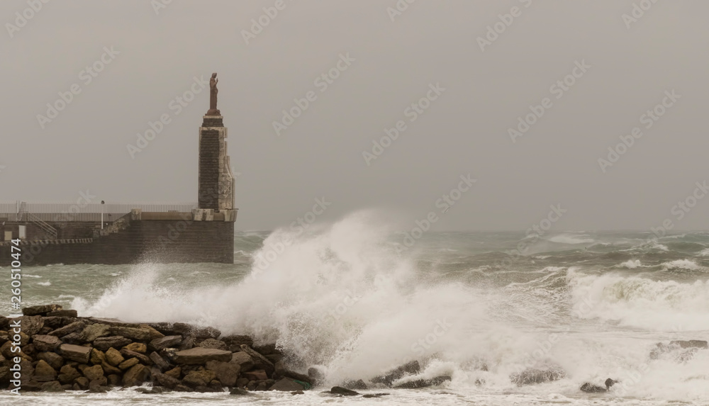 View of the Tarifa harbor statue in Tarifa on a cloudy windy day, Cadiz, Andalusia, Spain