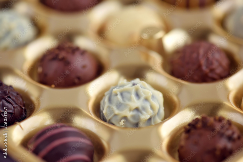 Assorted of chocolate candies in gold gift box. Selective focus Assorted of chocolate candies in gold gift box. Selective focus