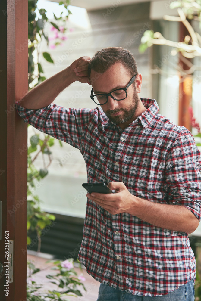 Fototapeta premium Modern man using cellphone outdoors.