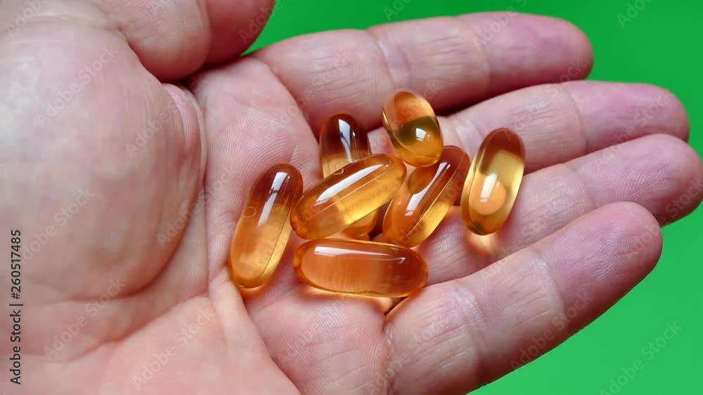 Vitamins Omega 3 in capsules on the hand. Take fish oil. take hand vitamins. Healthy lifestyle. Health heart and blood vessels. Vitamins Omega 3 in capsules on the hand. Take fish oil. take hand vitamins. Healthy lifestyle. Health heart and blood vessels.
