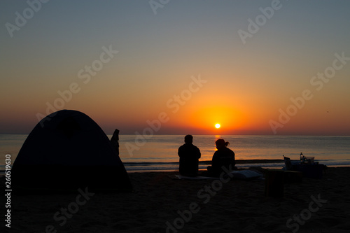 silhouette of couple on beach at sunset