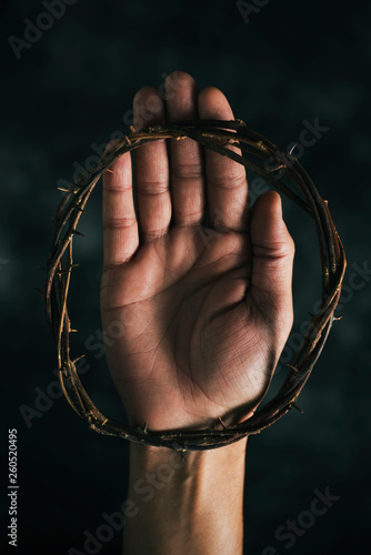 crown of thorns on the hand of a man