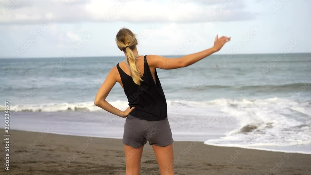 Young, fit woman stretching body, doing warmup on the beach Young, fit woman stretching body, doing warmup on the beach