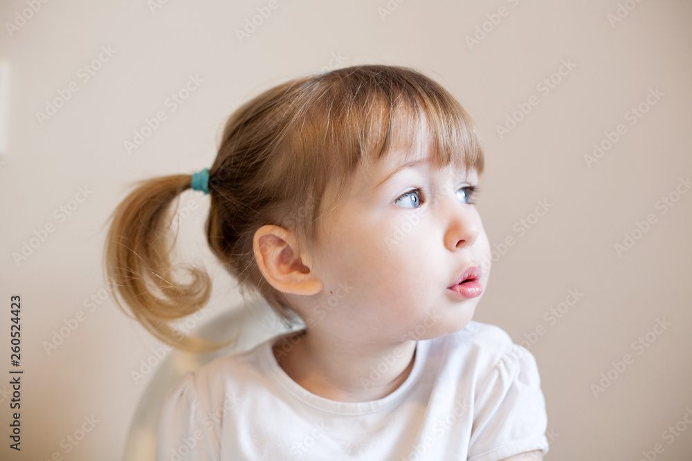 closeup face portrait of funny two years old blonde white girl on wall background closeup face portrait of funny two years old blonde white girl on wall background
