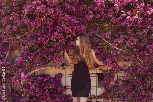 Fotografiet Portrait of girl among purple bougainvillaea
