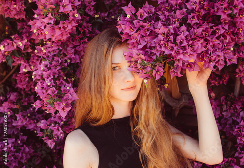 Photographie Portrait of girl among purple bougainvillaea