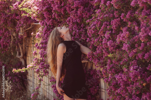 Fototapeta Portrait of girl among purple bougainvillaea