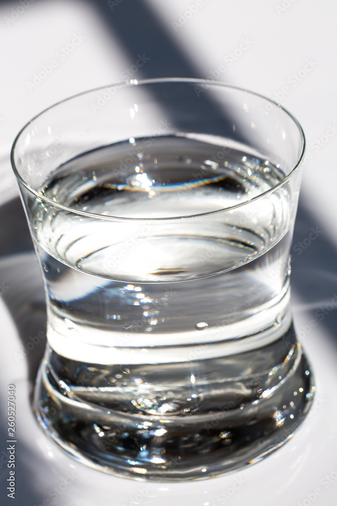 Transparent glass of clean water, Water drops on white background, Light & Shadow, Close up & Macro shot, Selective focus, Healthy Drink concept Transparent glass of clean water, Water drops on white background, Light & Shadow, Close up & Macro shot, Selective focus, Healthy Drink concept