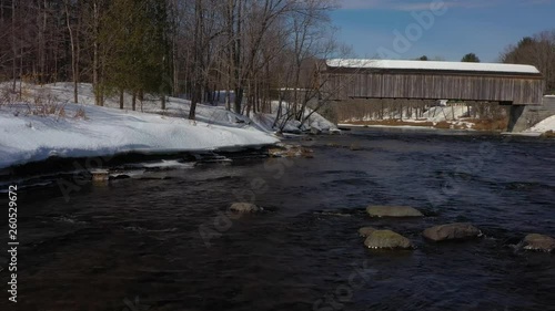 Wallpaper Mural Slowly flying upstream over rocks towards a covered bridge during early spring AERIAL Torontodigital.ca