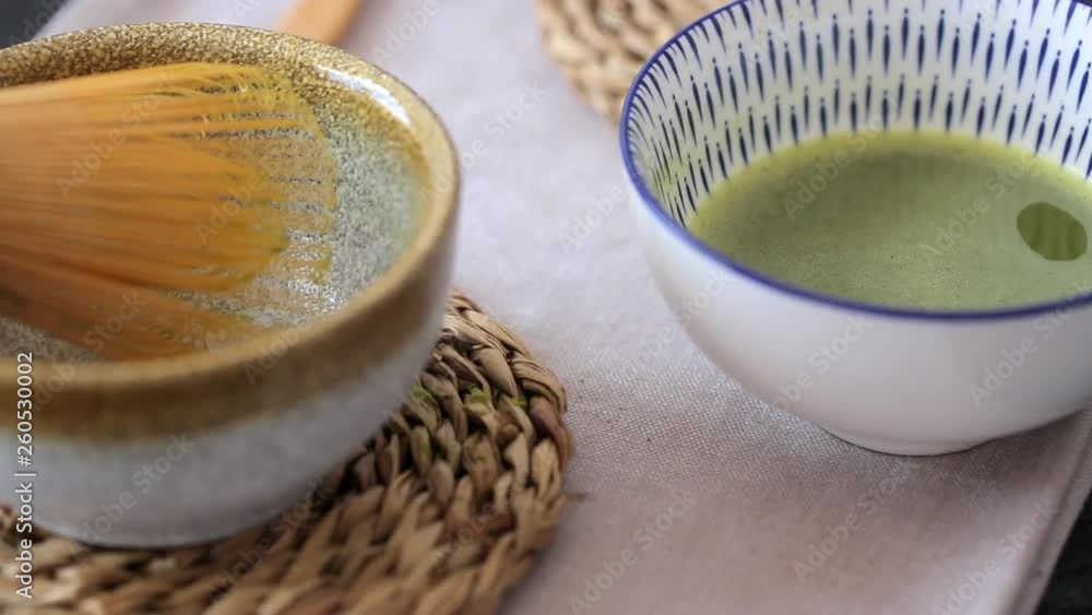 Man mixing green tea matcha in a bowl on blue surface. Drink is a rich source of antioxidants and polyphenols Man mixing green tea matcha in a bowl on blue surface. Drink is a rich source of antioxidants and polyphenols
