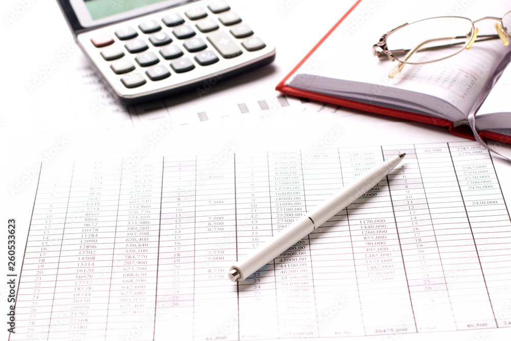 Accountant work table with calculator, charts and pen. Accountant work table with calculator, charts and pen.