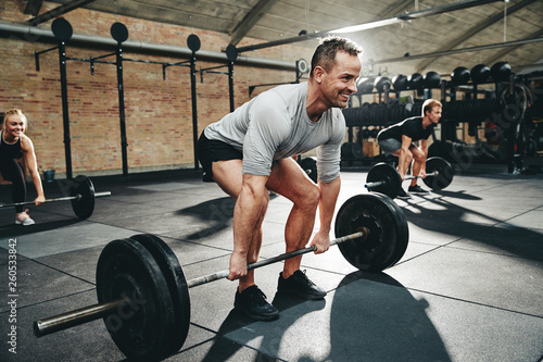 Fit man smiling during a gym weightlifting class