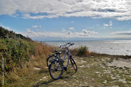 view of two bicycles parked and a view of a beach on a sunny Day, Baltic Sea Germany, bicycles on sea cliffs on the Coastal footpath with sky background and sea