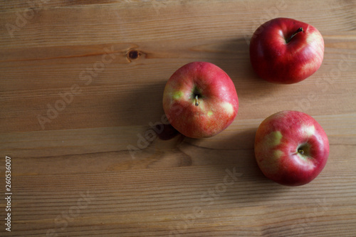 three red apples on a wooden background