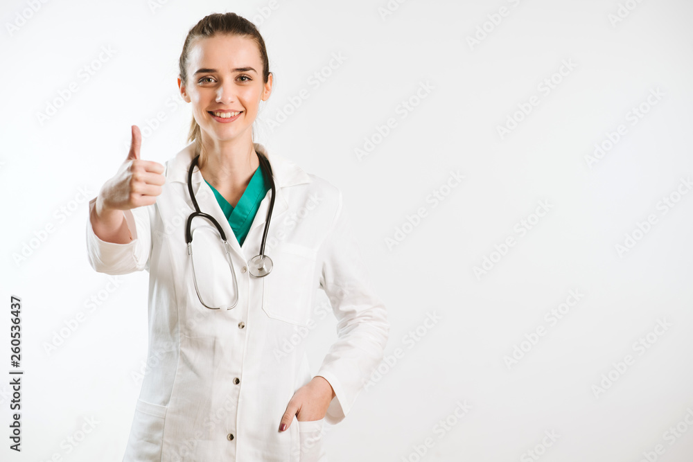 Young smiley nurse puts thumb up, wears scrub uniform and stethoscope. Young smiley nurse puts thumb up, wears scrub uniform and stethoscope.
