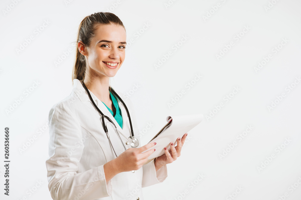 Young nurse with stethoscope and papers in her scrub uniform. Young nurse with stethoscope and papers in her scrub uniform.