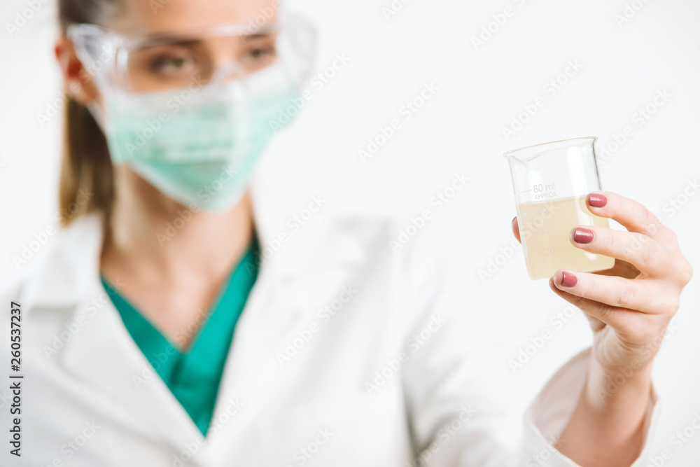 Young nurse holding a test tube, testin liquid. Young nurse holding a test tube, testin liquid.