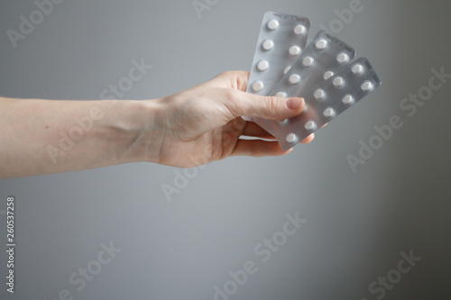 hand holding pallets of pills on a light background