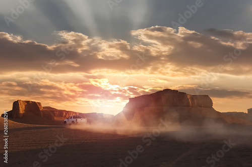 Dasht e Lut desert in Iran. The car in motion on the background of the sunset. Wild nature of Persia. photo